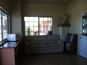 sala de estar con sofá y ventana en Village Inn, en Tulare