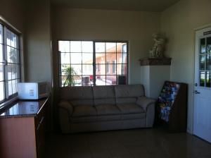 sala de estar con sofá y ventana en Village Inn en Tulare