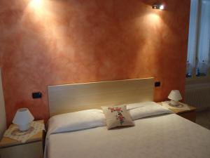 a bedroom with a large white bed with two lamps at La Cà in piaza in Cernobbio