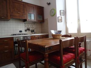 uma cozinha com uma mesa de madeira e alguns armários em La Cà in piaza em Cernobbio