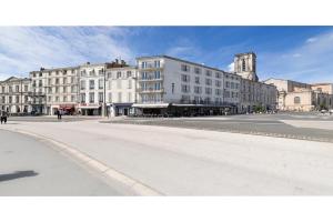 an empty street in a city with tall buildings at Hôtel Le Rupella in La Rochelle