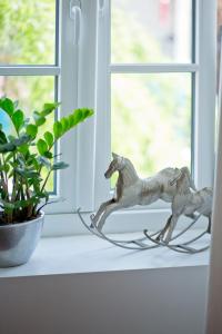 two metal horses on a window sill next to a plant at Rooms Zagreb 17 in Zagreb