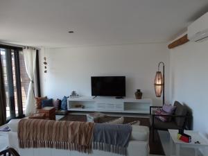 a living room with a couch and a flat screen tv at Casa de Praia in Juquei