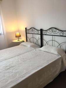 una camera da letto con un grande letto e un copriletto bianco di Apartamentos Arcos Costa Cálida ad Águilas