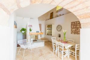 uma cozinha e sala de jantar com mesa e cadeiras em La Corte Della Masseria em San Vito dei Normanni