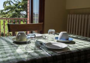 a table with plates and utensils on a table cloth at Camere Mariella in Bastia Umbra