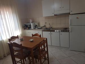 a kitchen with a table and chairs and a refrigerator at Guest House Vaso in Orma