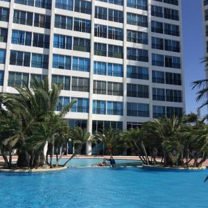 a swimming pool in front of a tall building at Punta Centinela Apartment in Punta Blanca