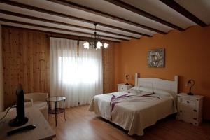 1 dormitorio con cama, mesa y ventana en Casona Santa Coloma en Matute de la Sierra