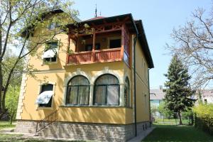 Una casa amarilla con balcón en la parte superior. en Anna Villa, en Keszthely