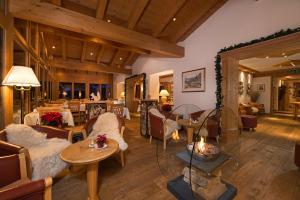 a living room with couches and tables and a fireplace at Hotel Dufour Alpin Superior - Adults only in Zermatt