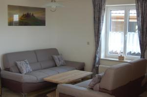 a living room with a couch and a table at Ferienwohnung Brock in Breitenbrunn +3 photos