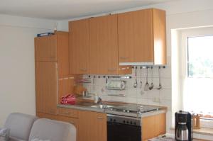 a kitchen with wooden cabinets and a stove at Ferienwohnung Brock in Breitenbrunn