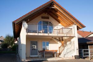 a small house with a balcony and a table at Ferienwohnung Brock in Breitenbrunn