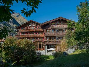 un gran edificio de madera con una montaña en el fondo en Hotel Dufour Alpin Superior - Adults only en Zermatt