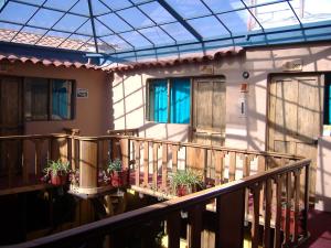 une maison avec des plantes en pot sur un balcon dans l'établissement Hostal Teatro Inka, à Cusco