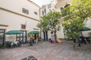 a courtyard of a building with tables and umbrellas at Due di Coppa in Scafati