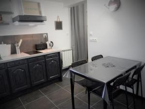 a kitchen with a table and some chairs and a counter at Le Gîte du Chêne Rouvre in Corbeil-Cerf