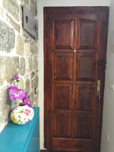 una puerta de madera junto a una mesa azul con un jarrón en Room N&M - Diocletians palace, en Split