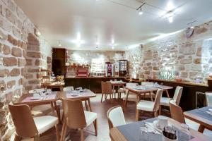 a restaurant with tables and chairs and a stone wall at Hôtel de Bellevue Paris Gare du Nord in Paris