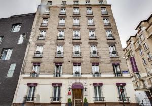 パリにあるホテル ドゥ ベルヴュー パリ ガル デュ ノールの窓とドアのある高いレンガ造りの建物