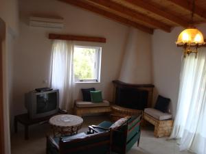 a living room with a couch and a tv at Three Bedroom Country House in Magoúla