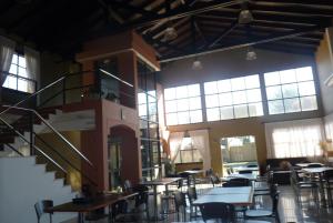 a dining room with tables and chairs and windows at Hotel Aybal in Salta