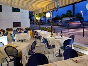a group of tables with white table cloths on a street at Hotel Ristorante Milton in Varazze