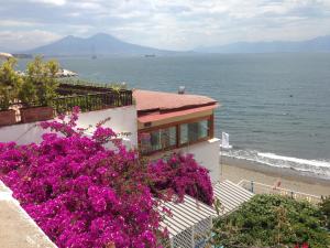 ein Haus mit lila Blumen am Strand in der Unterkunft Trimarchi House in Neapel