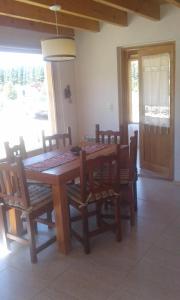 a dining room with a wooden table and chairs at Cabañas Wenuray in Villa Meliquina
