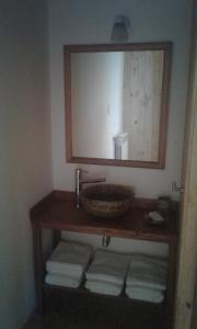 y baño con lavabo, espejo y toallas. en Cabañas Wenuray en Villa Meliquina