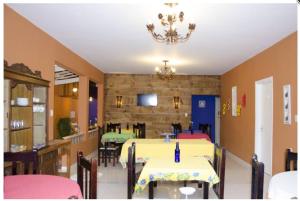 a dining room with tables and chairs and a chandelier at Hotel Gandhi in Jacutinga