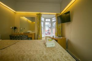 ein Hotelzimmer mit einem Bett, einem Waschbecken und einem Fenster in der Unterkunft Old Kings Arms Hotel in Pembroke