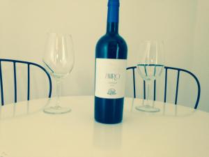 a bottle of wine sitting on a table with two glasses at Bed & Wine Rocco Zambri in Bovino