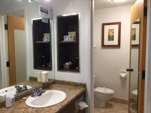 a bathroom with a sink and a toilet at Amosphère Complexe in Amos