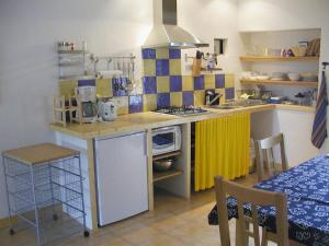 - une petite cuisine avec un comptoir et une cuisinière dans l'établissement Gîte Périssé, à Libaros