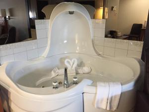 a bath tub with a sink in a bathroom at Amosphère Complexe in Amos