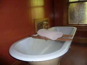 a bathroom with a tub with a towel on it at Hilltop Accommodation Catlins in Papatowai