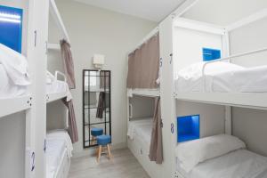 马拉加Malaga Stop Hostel AB的宿舍间设有四张双层床和一把椅子。