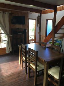 een eetkamer met een houten tafel en stoelen bij La Maison des Fous in Papudo