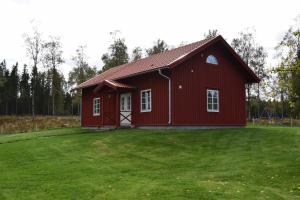 un fienile rosso con un prato davanti di Kronobo a Marieholm