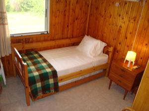 a small bed in a wooden room with a window at Three Bedroom Country House in Magoúla