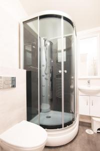 e bagno con doccia, servizi igienici e lavandino. di Guesthouse Grund a Grindavík