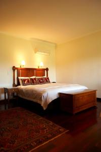 een slaapkamer met een groot bed en een tapijt bij Lazy River Boutique Bed & Breakfast in Pinjarra