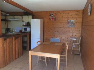 cocina con mesa de madera y nevera en chez steph&aurore, en Lacanau