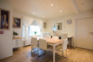 a dining room with a table and white chairs at Guesthouse Grund in Grindavík