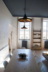 comedor con mesa de madera y lámpara de araña en Appartement Du Fau De La Roque, en Villefranche-de-Rouergue