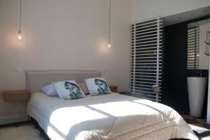 ヴィルフランシュ・ド・ルエルグにあるAppartement Du Fau De La Roqueのベッドルーム1室(白いベッド1台、枕2つ付)