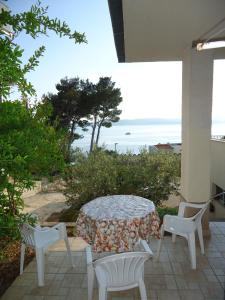 a patio with a table and chairs and the ocean at Apartments Marica in Brela