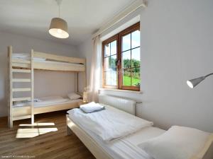a bedroom with two bunk beds and a window at Carlina House in Szczawnica